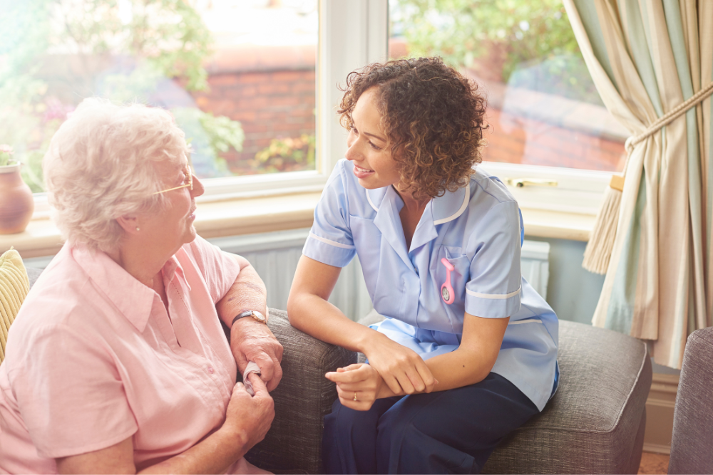 A worker talking to a patient in a care home.